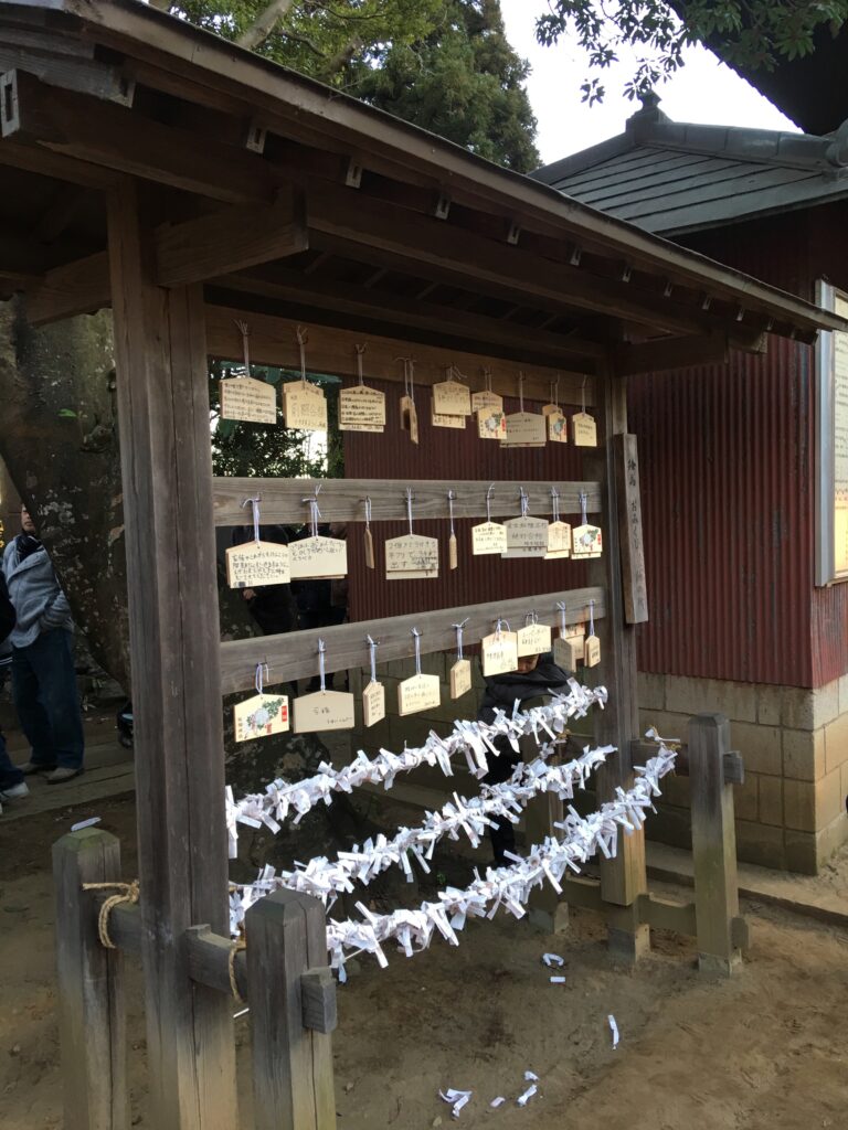 Ema (wooden tablets to write prayers) and Omikuji tied up at the temple